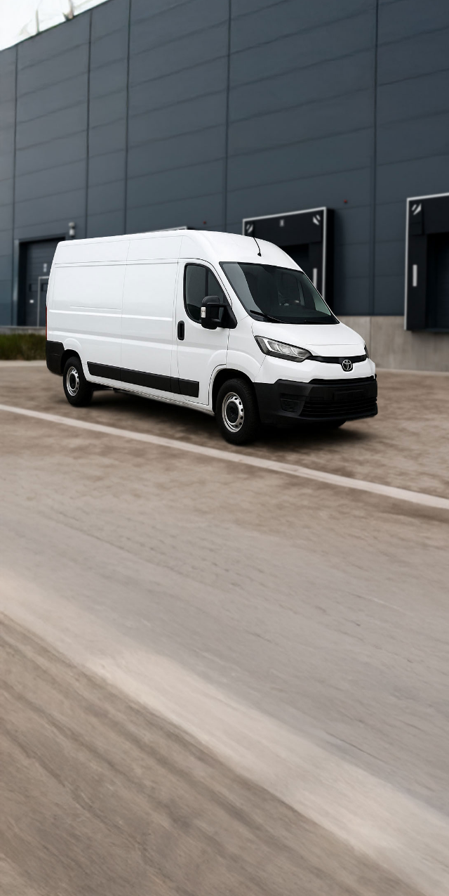 Bílá dodávka zaparkovaná před budovou skladiště